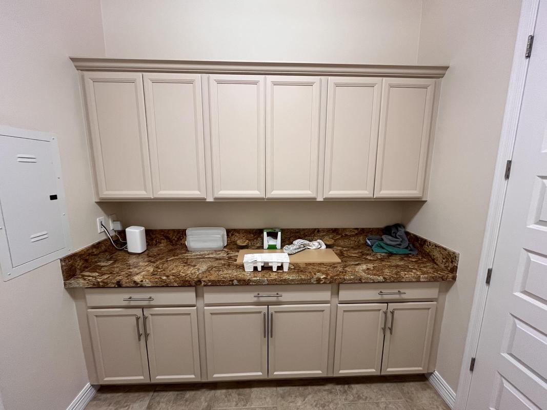 Green Valley Painting Company cabinetry by Piper Family Painting Company shows a clean, modern laundry room with expertly painted cabinets and a polished look.