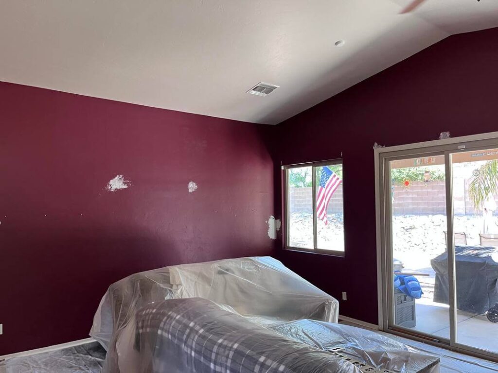 Green Valley Painting Company project by Piper Family Painting Company showing a maroon room with prep work and natural light through windows.